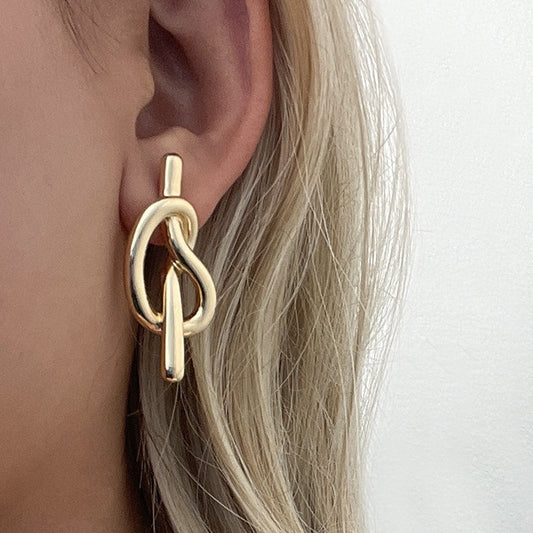 Art minimal européen et américain, nœuds froids, courbures et nœuds, boucles d'oreilles en spirale anti-moustiques.