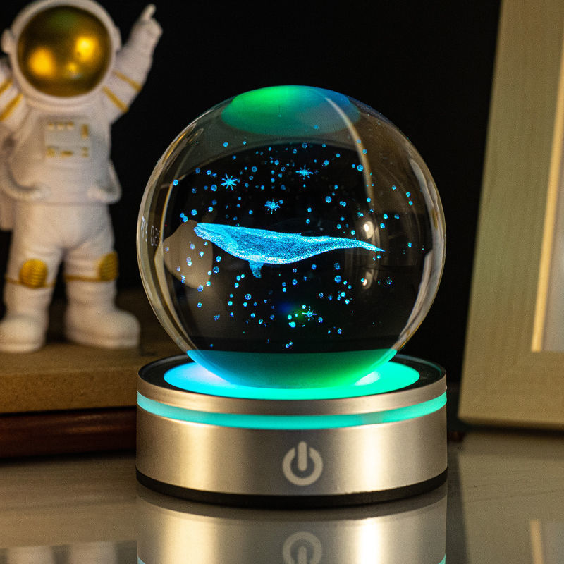 Sélection de cadeaux pour la maison : petite lampe de nuit colorée avec une boule de cristal lumineuse en 3D gravée à l'intérieur.