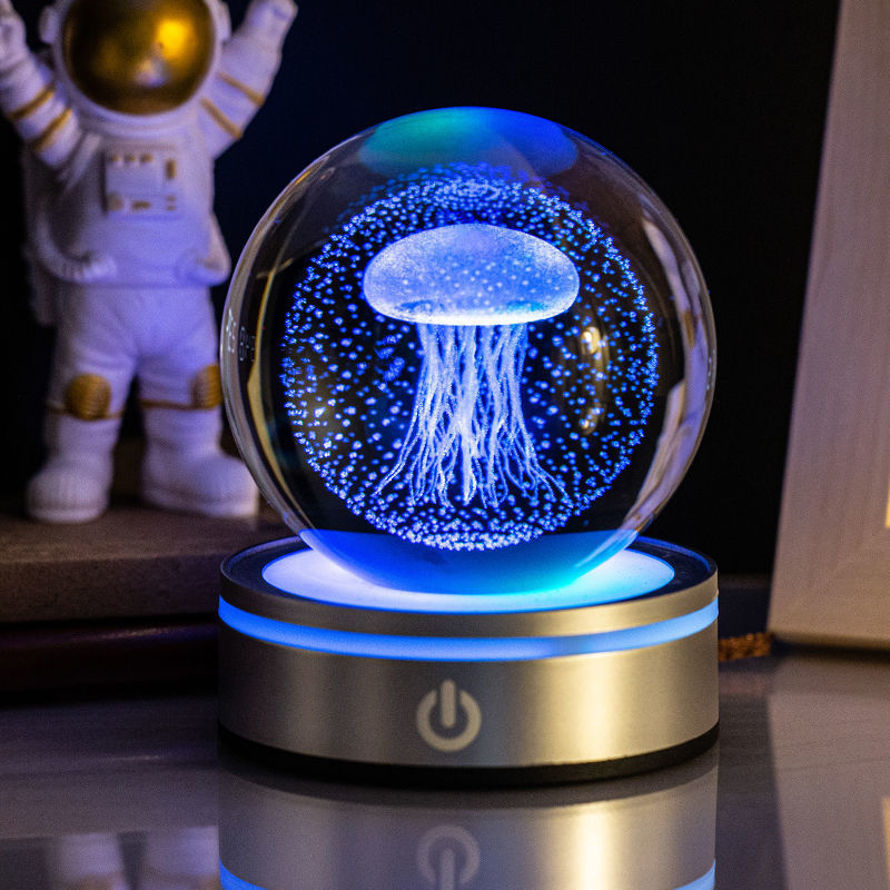 Sélection de cadeaux pour la maison : petite lampe de nuit colorée avec une boule de cristal lumineuse en 3D gravée à l'intérieur.