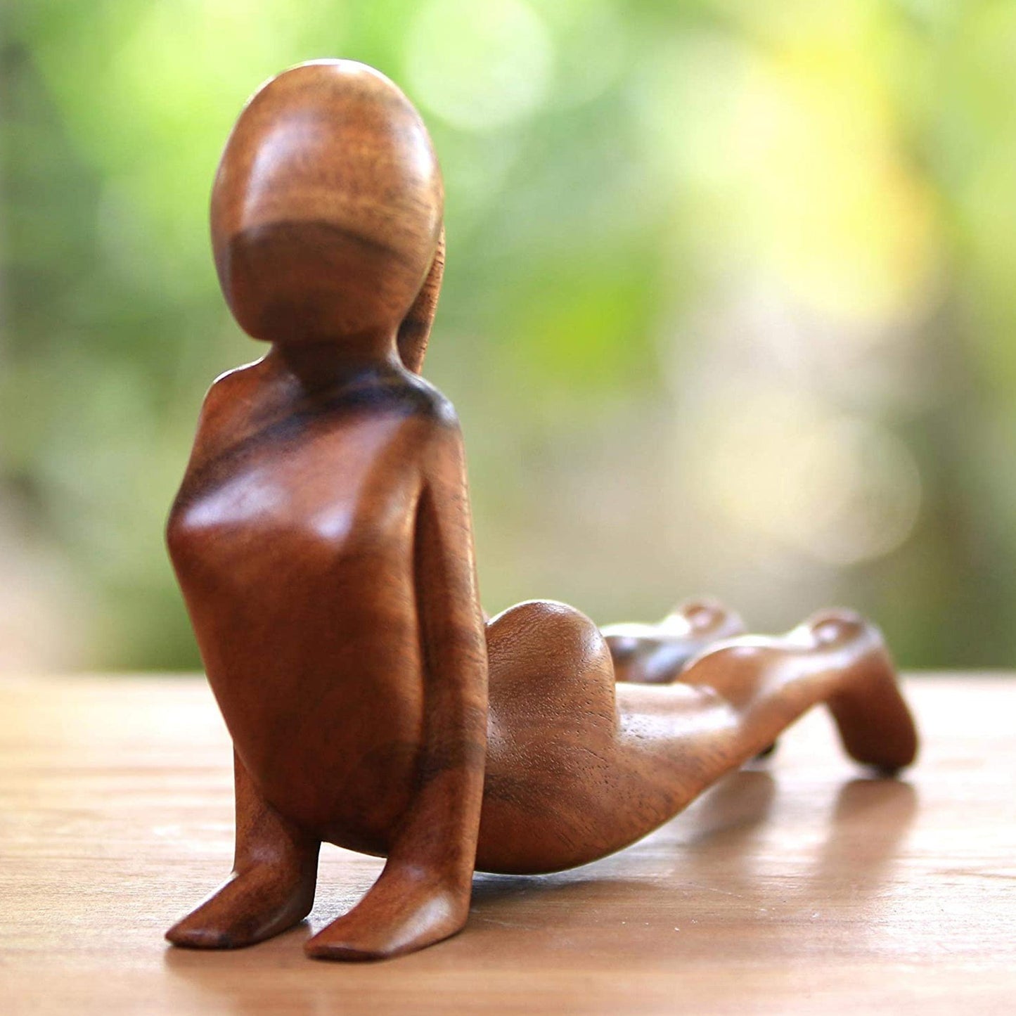 Ornements de nains de jardin en position de yoga avec des feuilles de figuier.